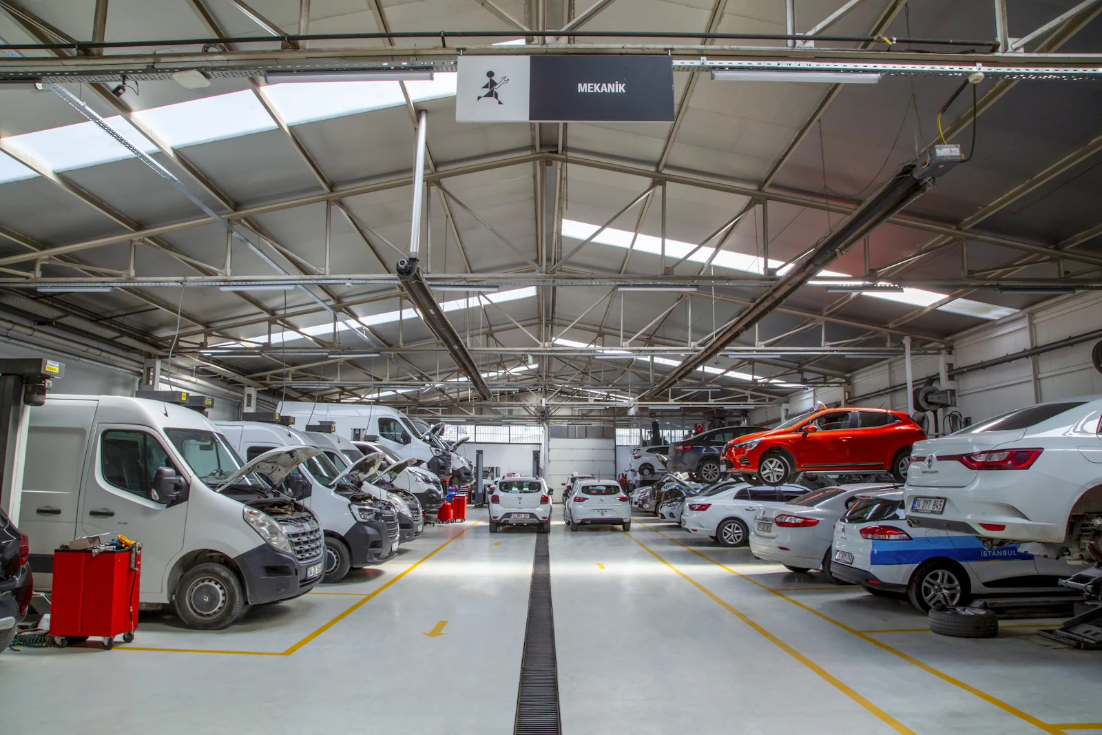 Vue large d'un atelier de carrosserie avec véhicules en cours de réparation